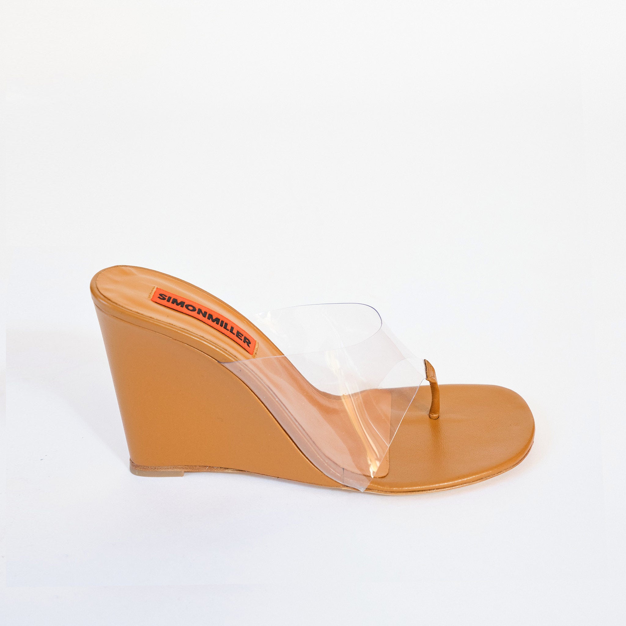 Side view of a high heel wedge sandal with clear PVC upper and thong detail, in toffee brown vegan leather.