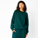 A model wears the classic raglan sweatshirt by Les Tien in an emerald green color - front view.