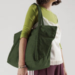 Close half body photo of model holding the Cloud Bag - Bay Laurel.