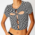 A model wears the black and white checkered cut out tee by Misc Etc, close up of cut outs.