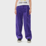 A model wears bright purple corduroy pants from GANNI featuring a cool, baggy fit.