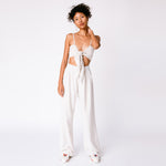 A model wears the high rise linen trousers by Misc Etc, paired with the Tie Top and sneakers, full outfit view.