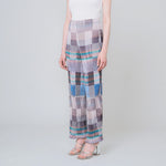 Pleated high waist trousers with a gridded graphic pattern in greys, whites, and blues - angled view on model.