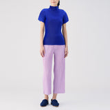 Full body photo of model wearing the Thicker Bottoms Pants - Pink Purple, a pleated straight leg pant.
