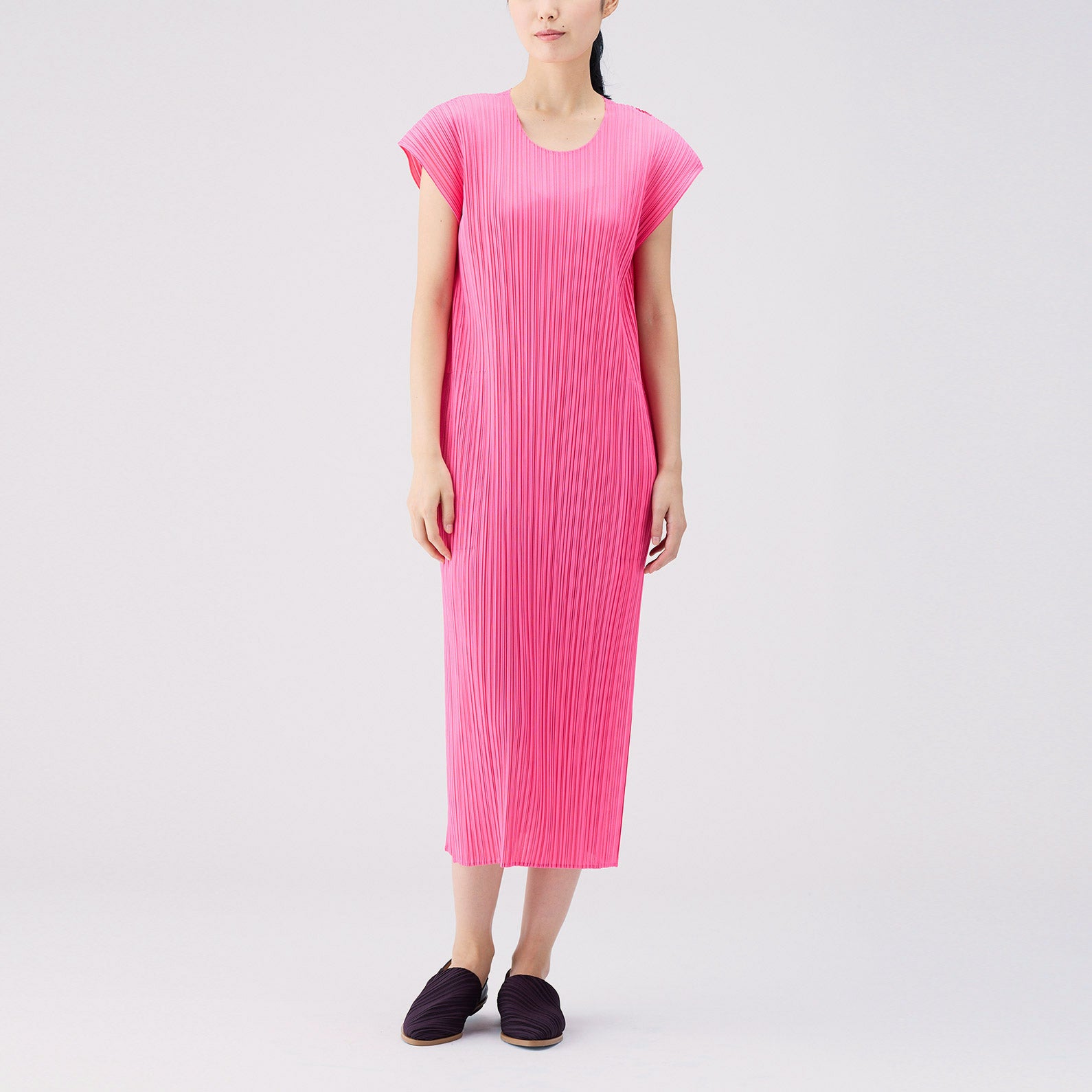 Full body photo of model wearing the Monthly Colors July S/S Dress - Bright Pink, a short sleeved full length pleated dress.
