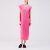 Full body photo of model wearing the Monthly Colors July S/S Dress - Bright Pink, a short sleeved full length pleated dress.
