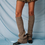 A model wearing the light brown ribbed Luxy Leg Warmers by Sandy Liang, and black loafers.