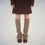 Front photo of model wearing the brown leg warmers paired with brown ballet flats and a brown skirt. 