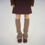 Front photo of model wearing the brown leg warmers paired with brown ballet flats and a brown skirt.