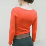 Back half body photo of model wearing the Maria Scoop Neck - Blood Orange.