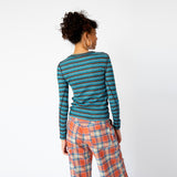 Back view of the blue and brown striped Cardio Crew by Collina Strada featuring rhinestones on the chest in the shape of a teddy bear and swirls, paired with orange and white plaid wide leg pants..