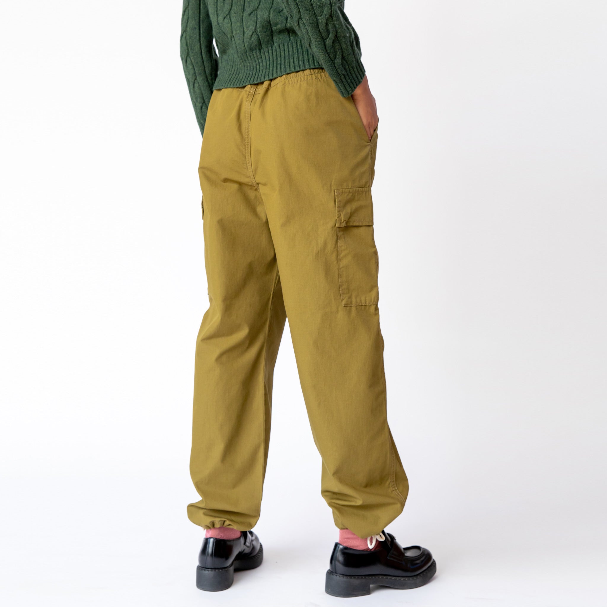 Back view of the olive green Ripstop Cargo Beach Pant by Stussy, paired with black loafers.
