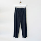 Hanger photo of black Pleats Please pants with a full straight leg, thicker pleating, and hidden side pockets.