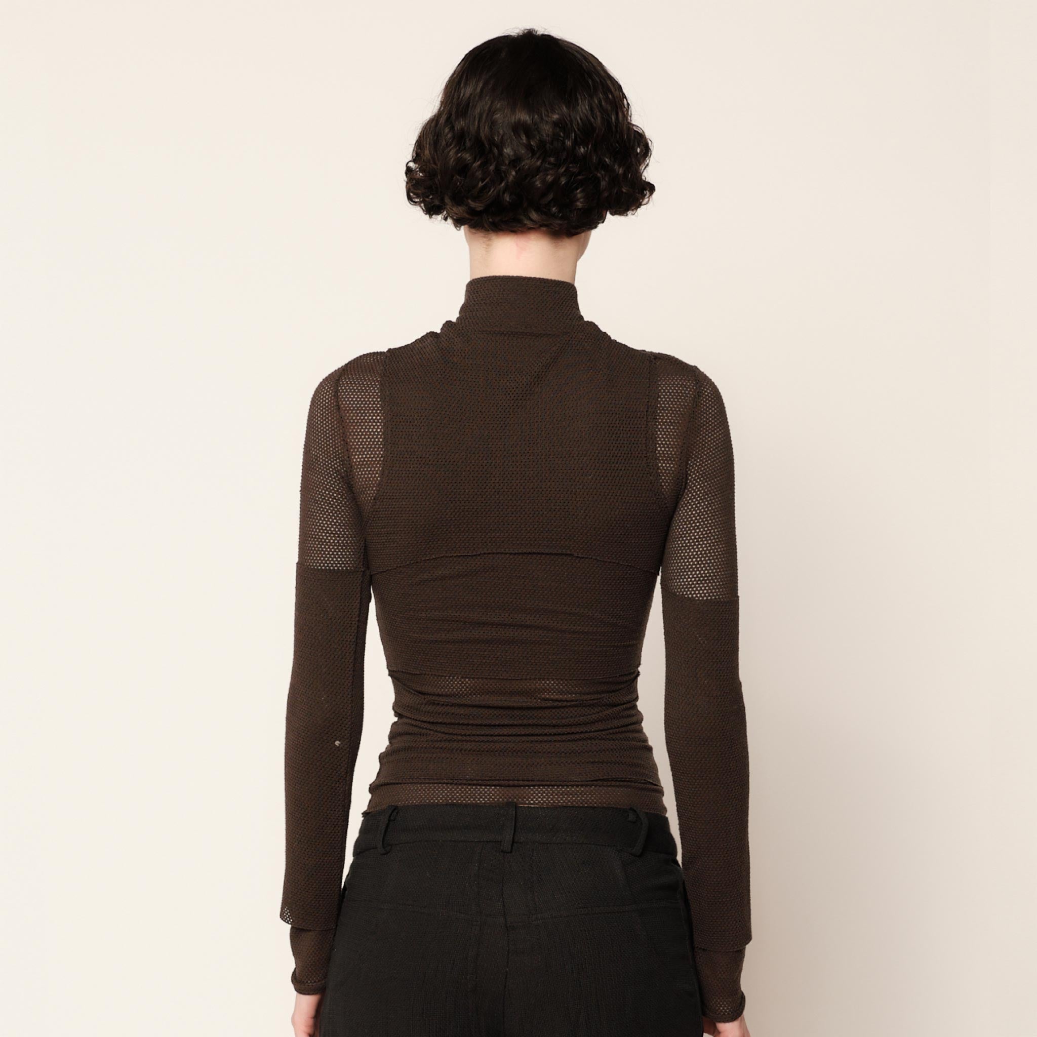 Back half body photo of model wearing the Eclipse Turtleneck - Stone.