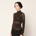 Side half body photo of model wearing the Eclipse Turtleneck - Stone.