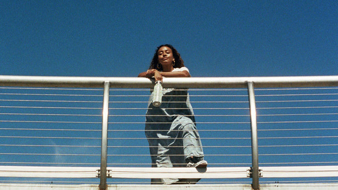 Photograph of Hike Clerb founder Evelynn Escobar wearing Ganni x Levis on a bridge - photographed by Tiana Marie Combes for LCD.