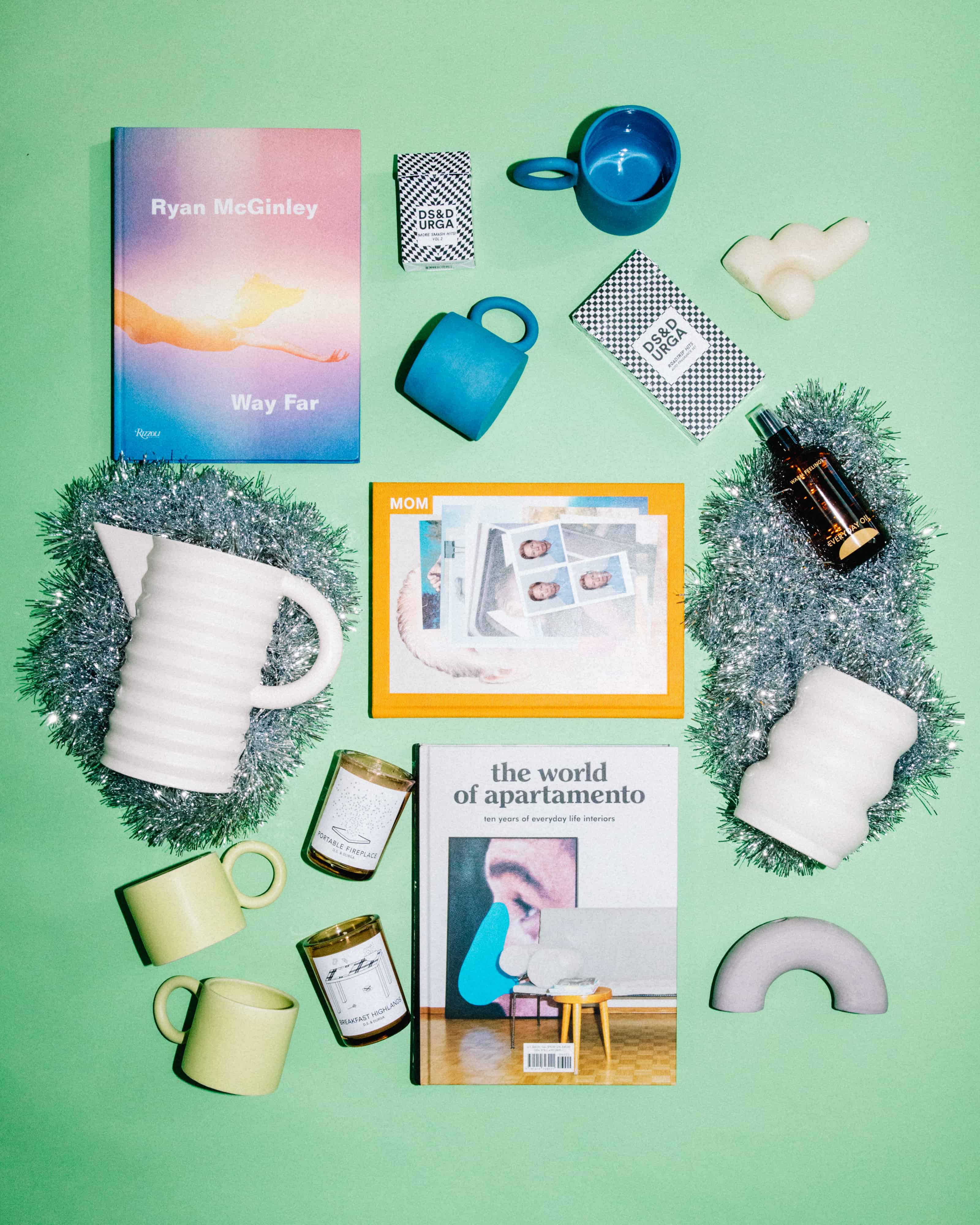 Close detail flat lay of various different holiday gifting items. The photo features books, mugs, ceramic vases & more.