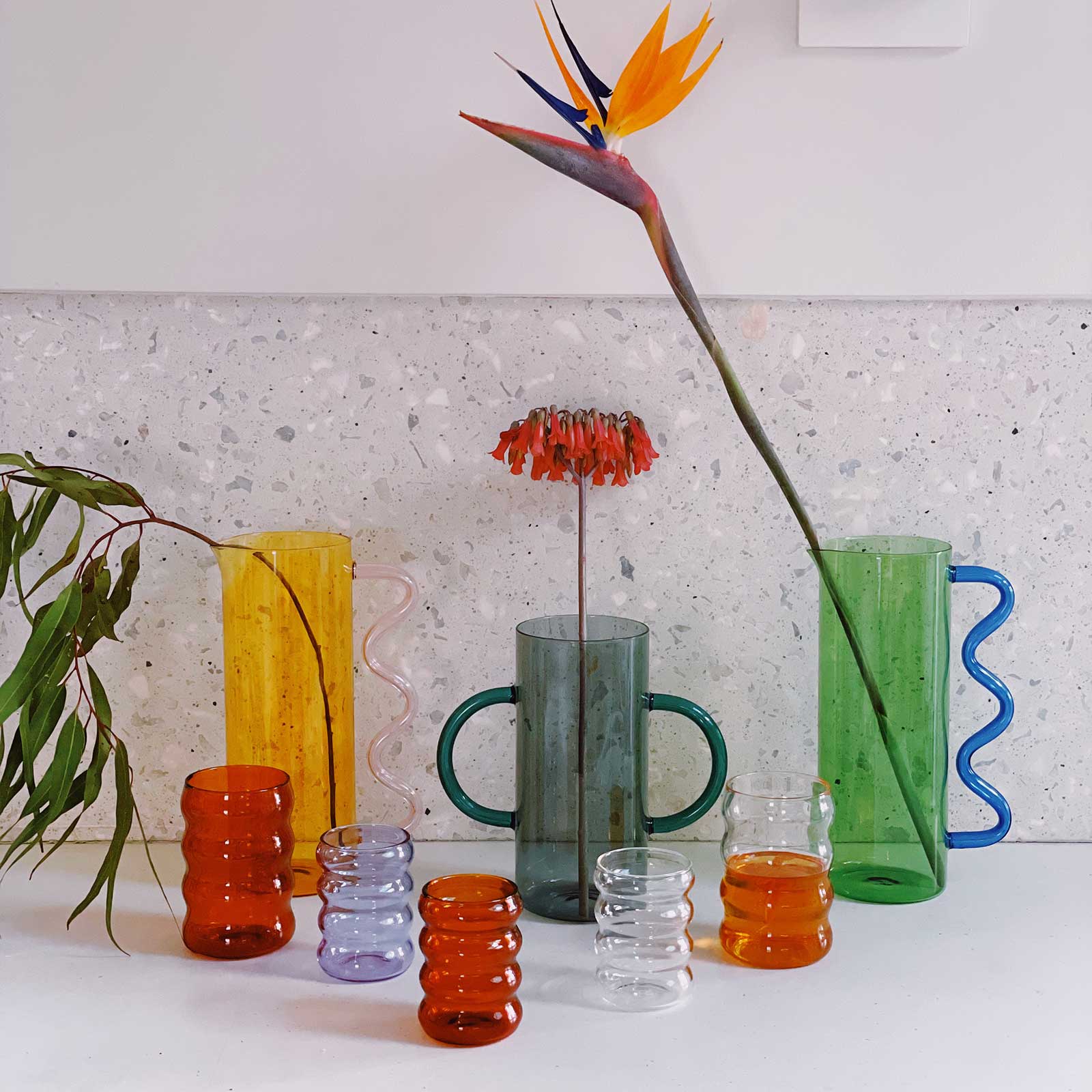 Photograph of various colorful glassware and vases designed by Sophie Lou Jacobsen.