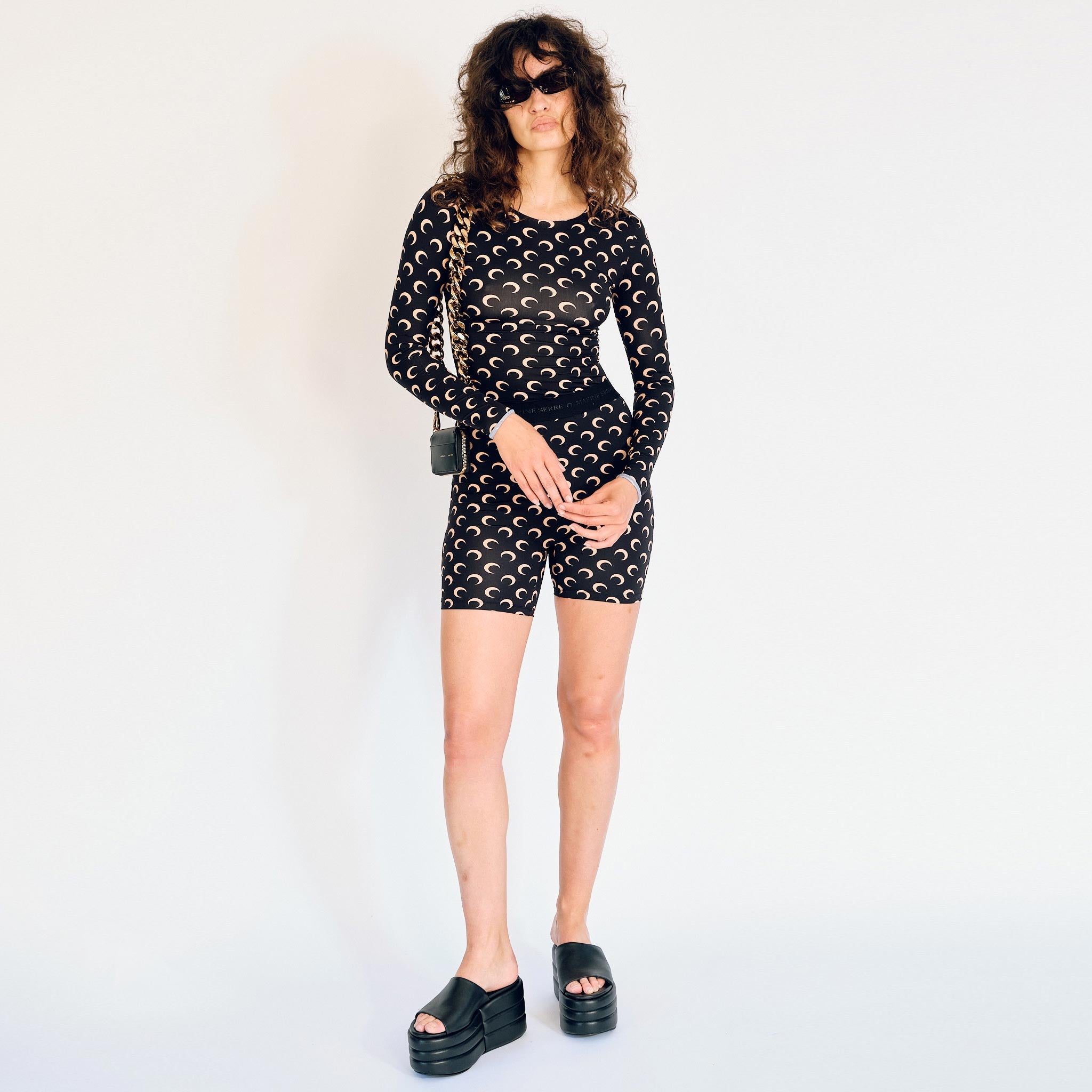 A model wears the Regenerated Second Skin bike shorts in black with tan colored moon print - full outfit view.