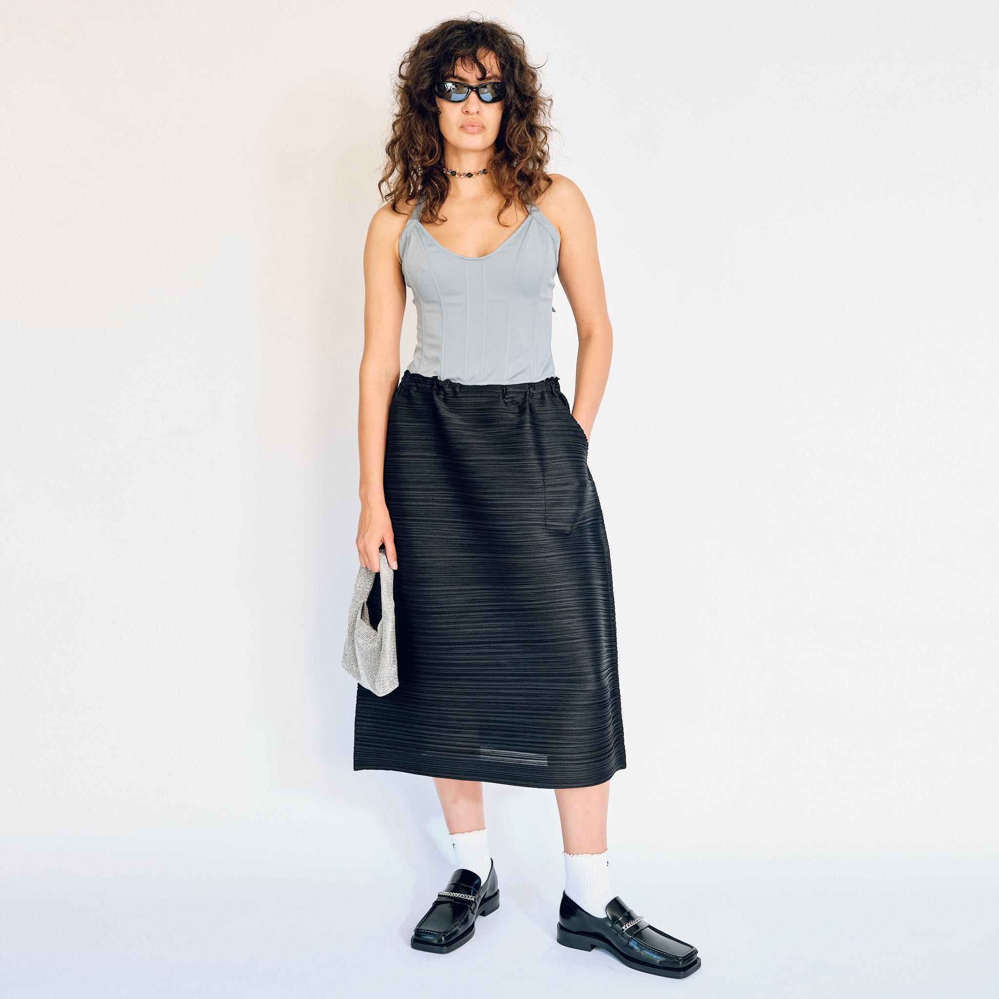 Horizontally pleated bouncy fabric black skirt by Pleats Please, full outfit view on model.