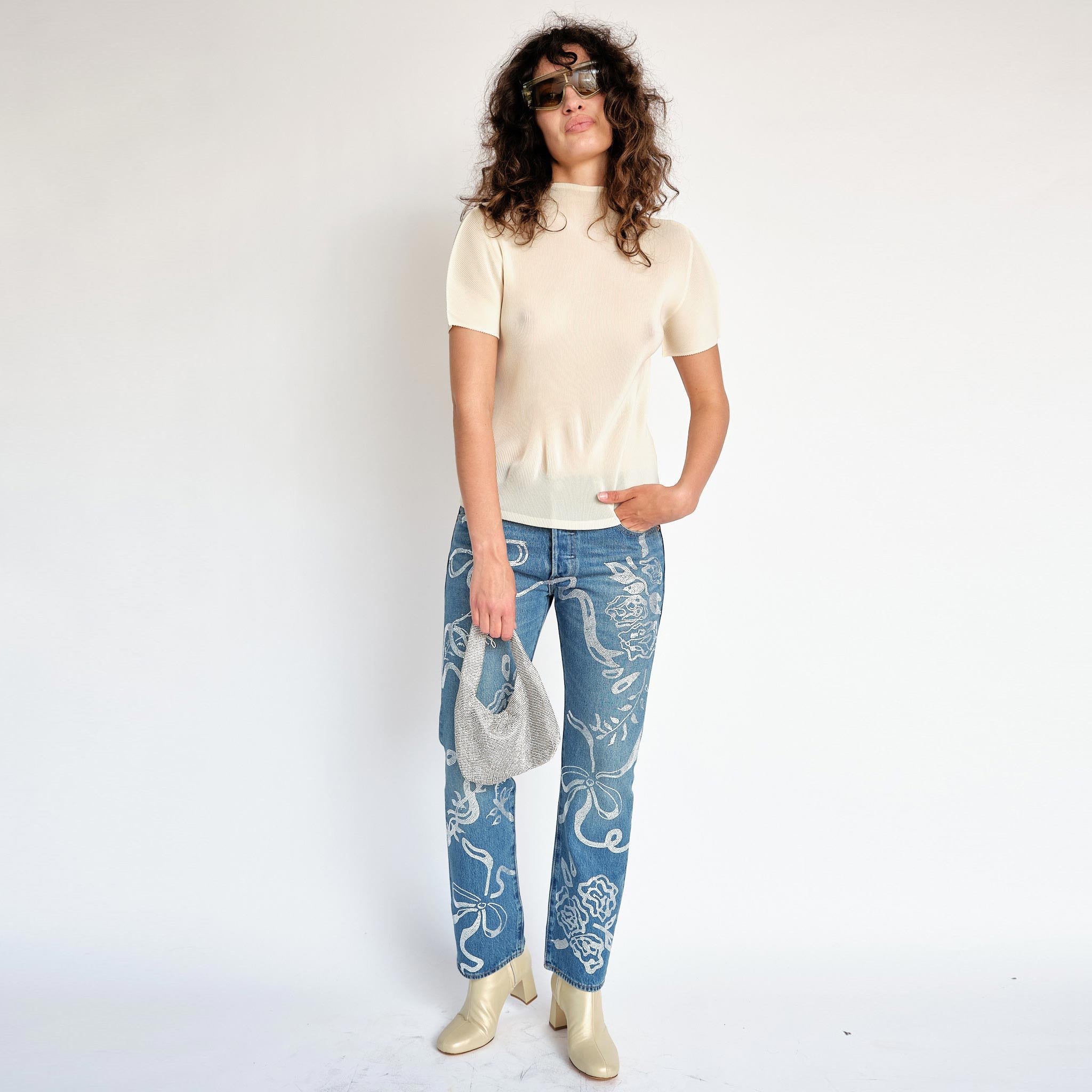 Classic Pleats Please Mist Top with slight mock neck and short sleeves in a light lemony cream color way - full outfit view on model.