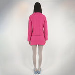 Back full body photo of model wearing a pink knit set featuring a button up sweater and a mini skirt.