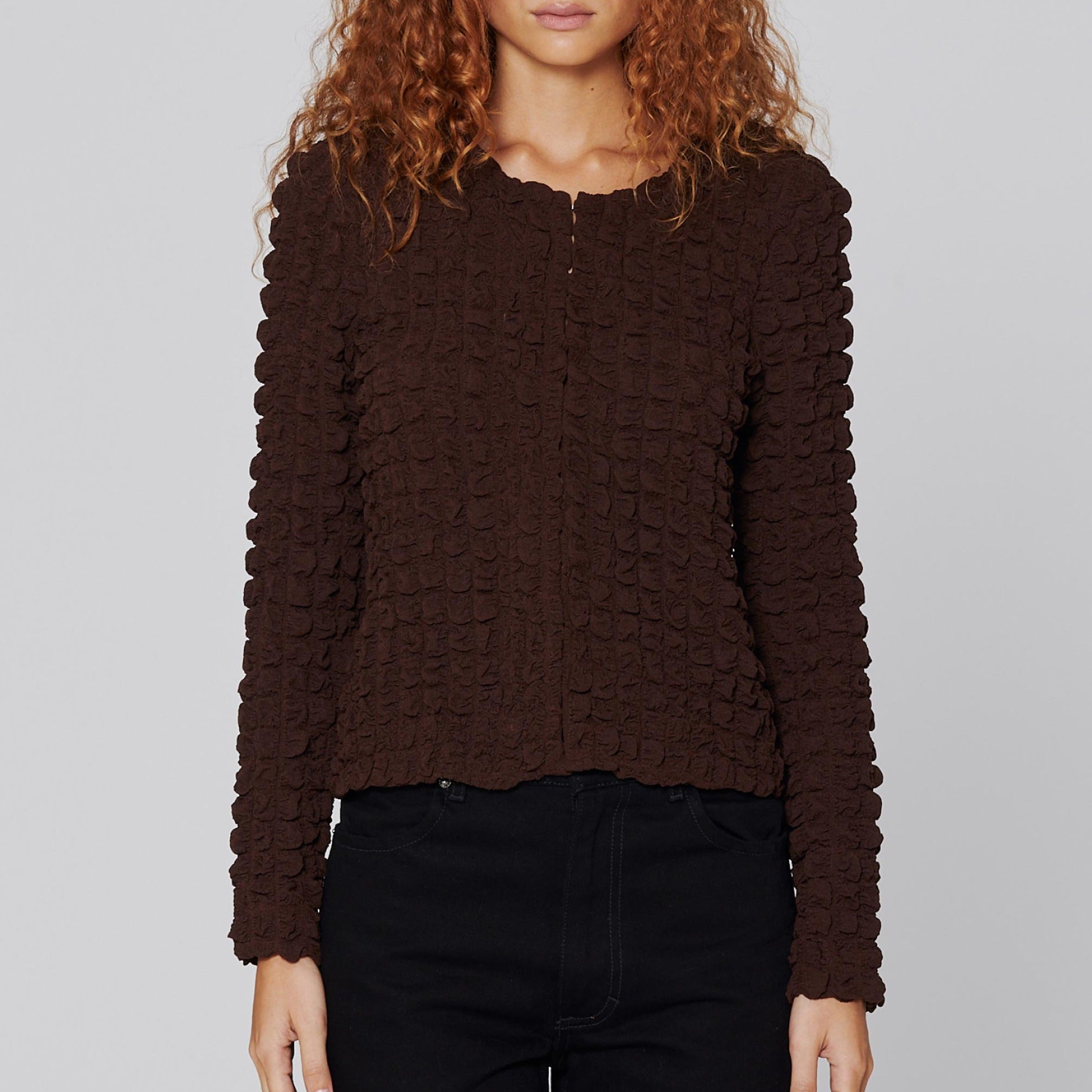 Front half body photo of model wearing the Bubble Cardigan - Umber.
