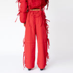Back half body photo of model wearing the Cam Pants. The pants feature bow details down the side. 