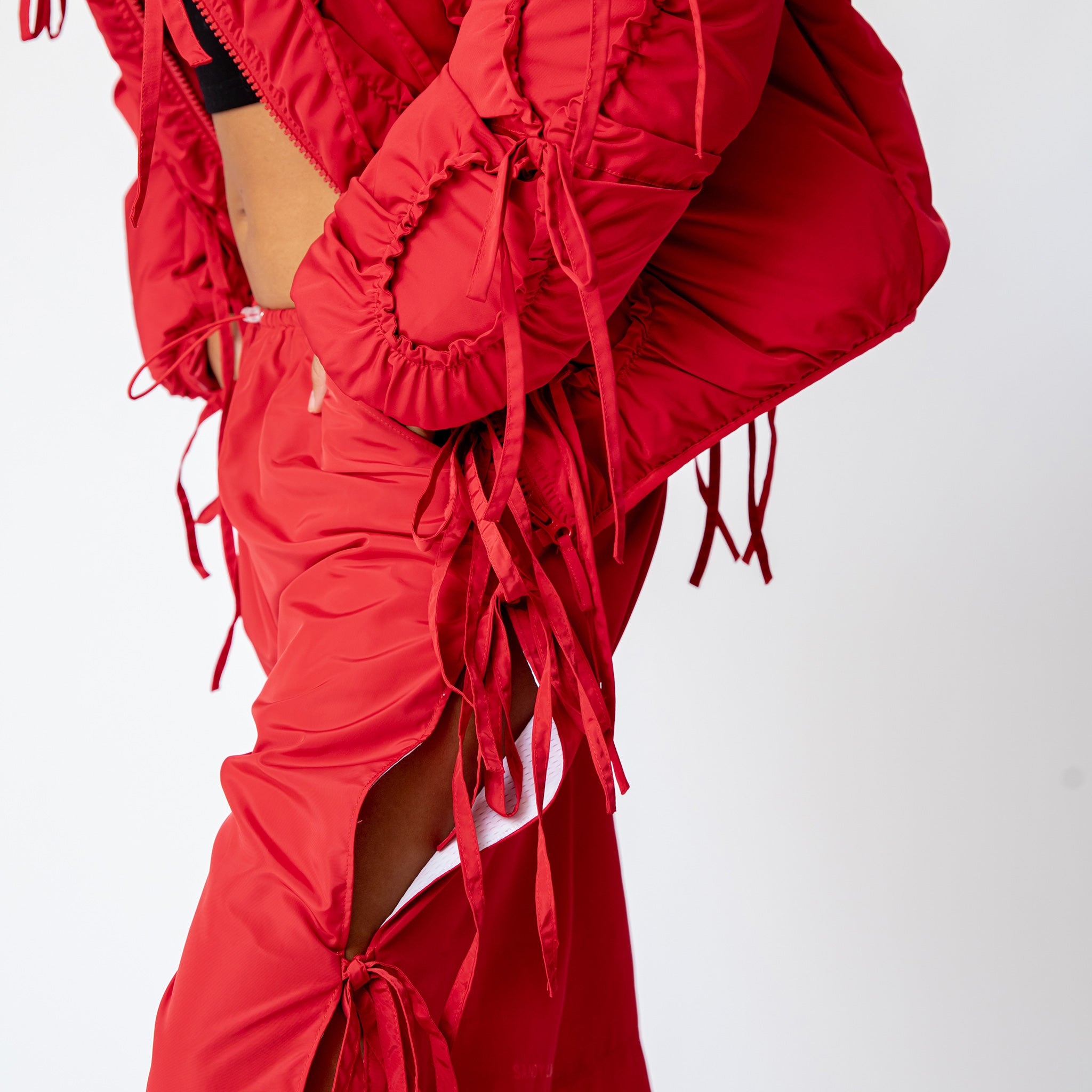 Side half body photo of model wearing the Cam Pants with bow details down the side.