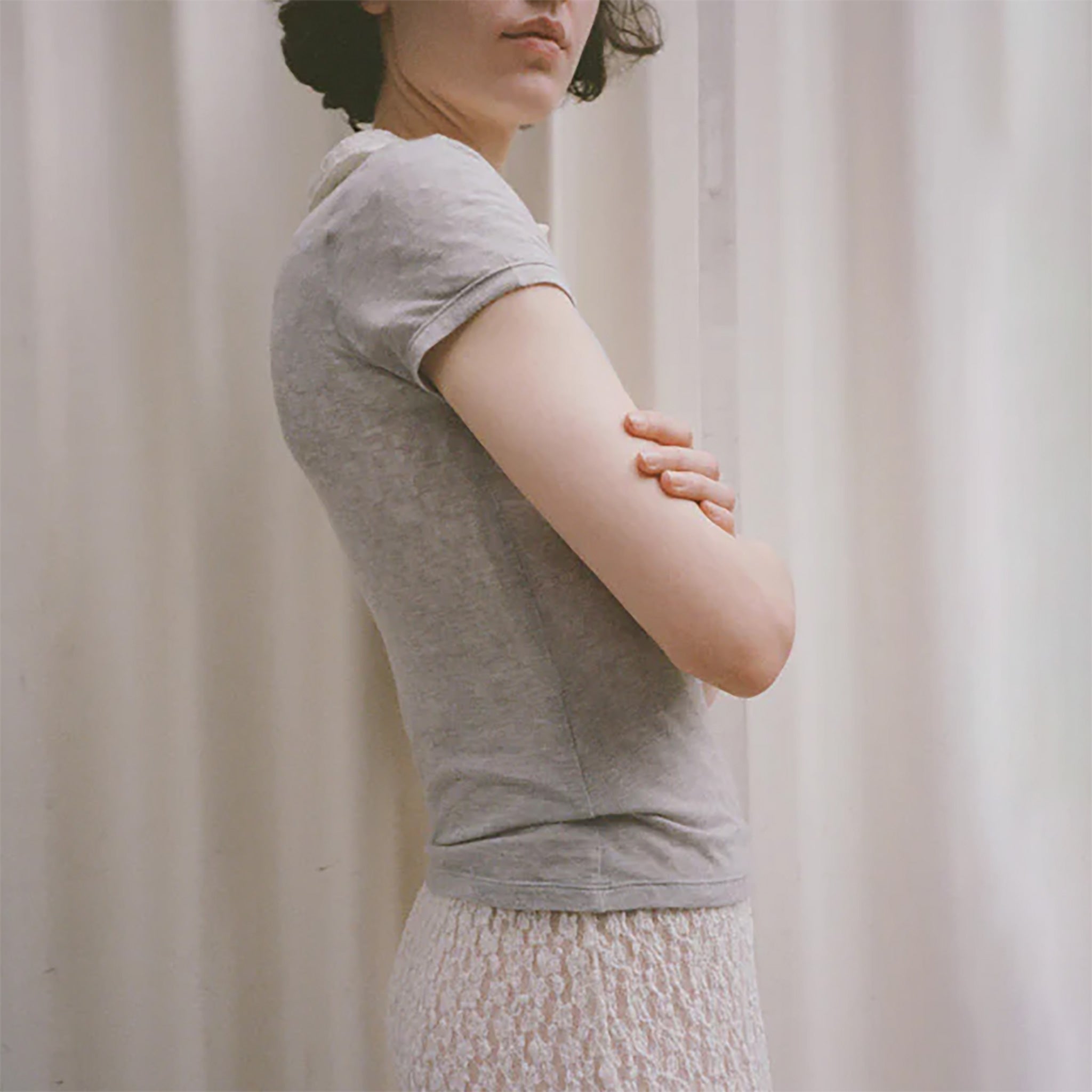Side half body photo of model wearing the Campos Tee - Smoke.