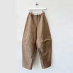 Brown crinkled cotton canvas pants with stitching across the knee and an exaggerated balloon-like shape.