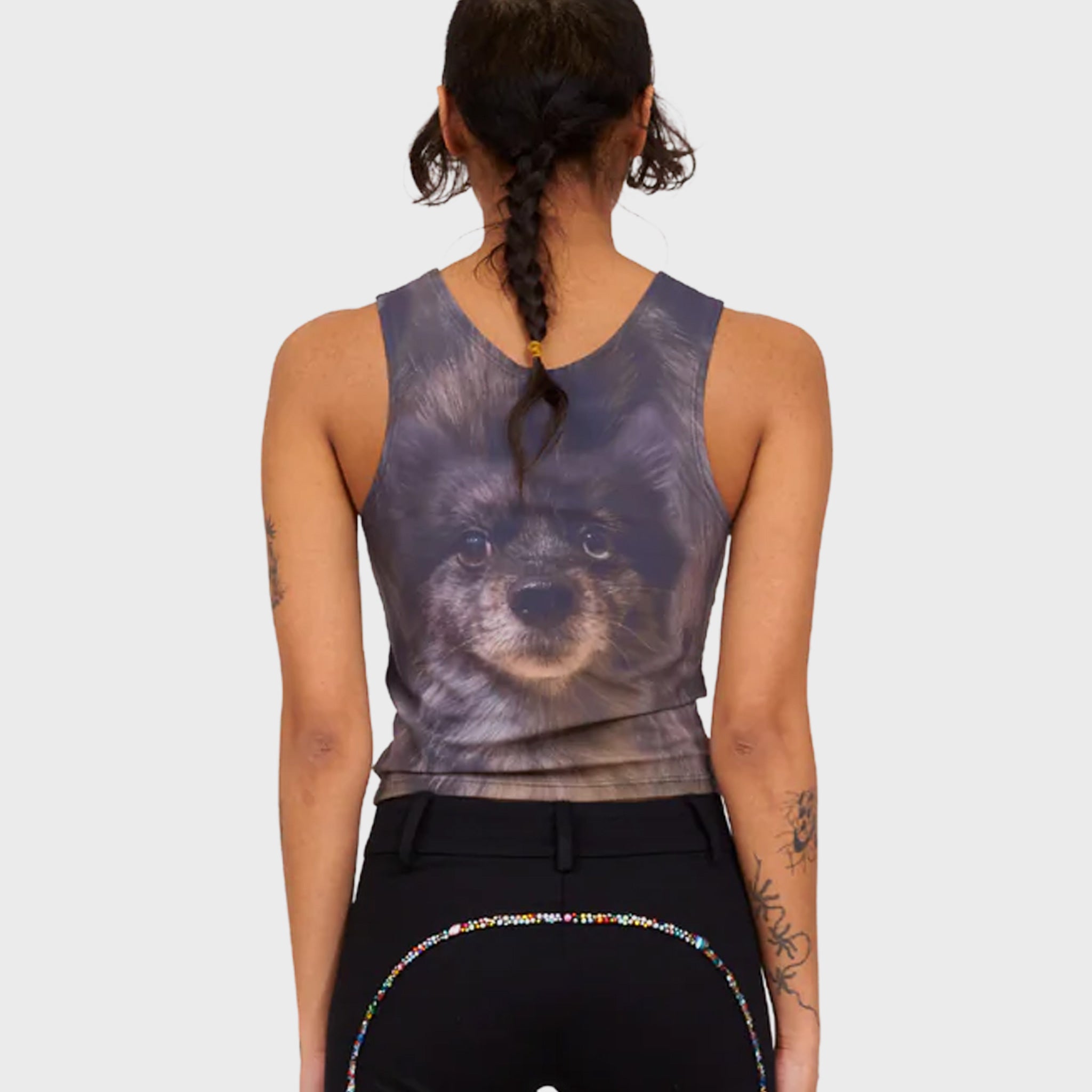 A model wears a fitted tank top printed with the face of a cute black dog - back view.