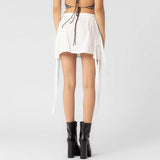 Back half body photo of model wearing the Cargo Strap Mini Skirt - White.