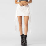 Close half body photo of model wearing the Cargo Strap Mini Skirt - White.