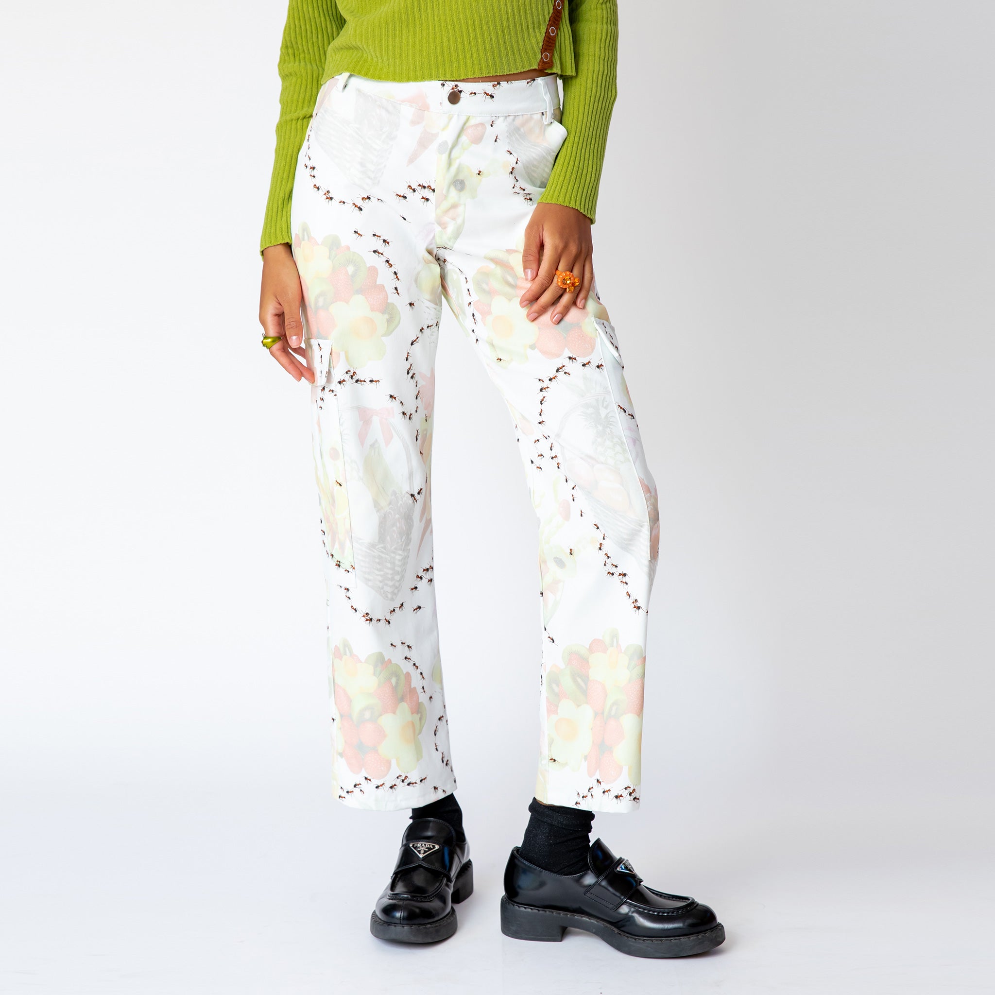 A model wears the Chason Cargo Pant in Antsanity Print featuring graphics of fruits and ants crawling in circular paths, front view. 