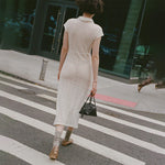 Back full body photo of model walking across the street wearing the Choice Dress - Ivory.
