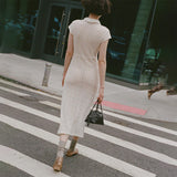 Back full body photo of model walking across the street wearing the Choice Dress - Ivory.