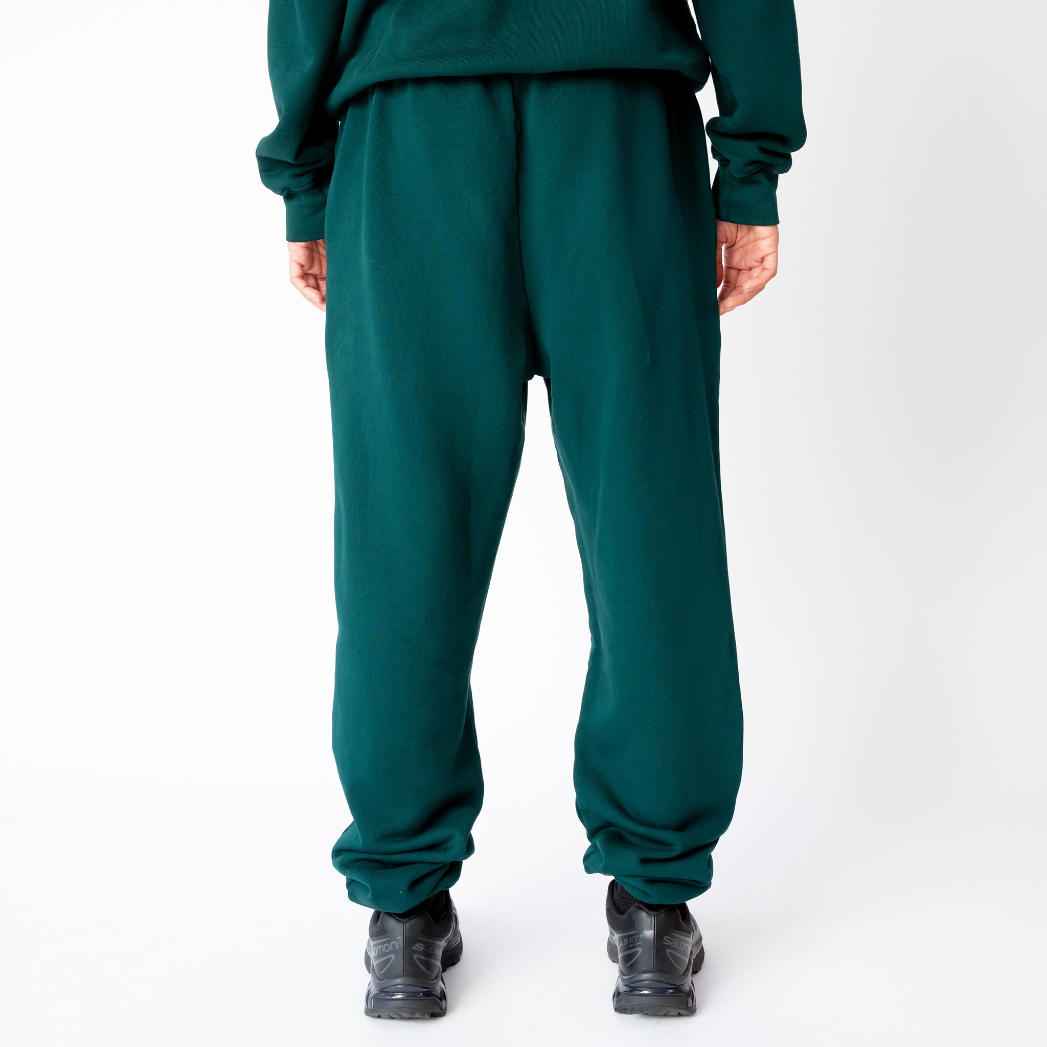A model wears the classic sweatpant by Les Tien in an emerald green color - back view.