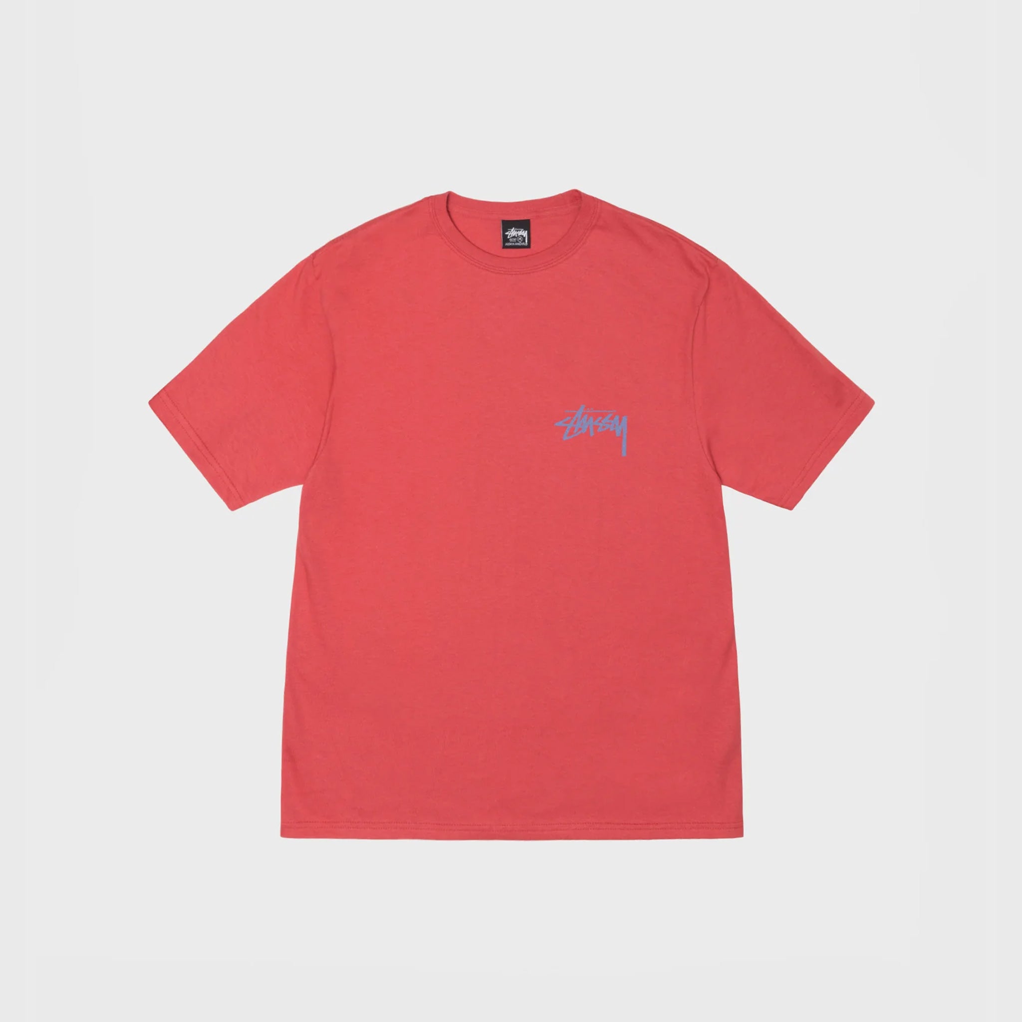 Flat photo of the front of a red t shirt with the stussy logo in blue writing.