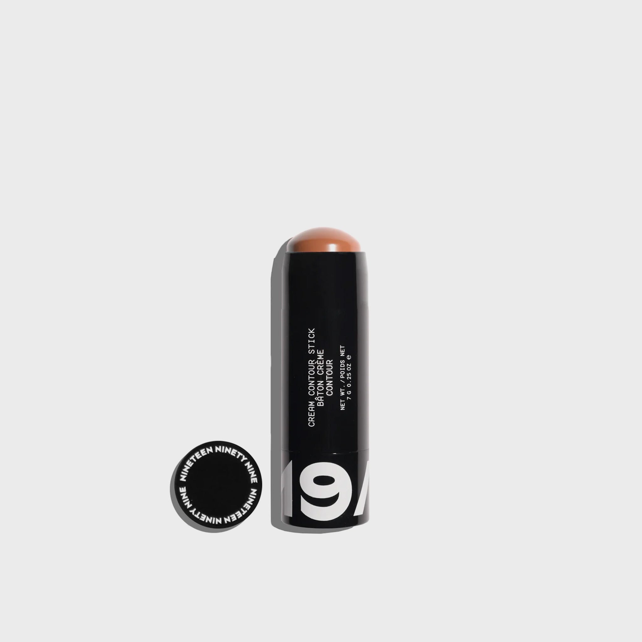 A small black makeup stick with bold 19/99 logo printed on black packaging showing the medium hued brown contouring makeup.