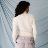 Back view of a soft-looking white wrap sweater by GANNI