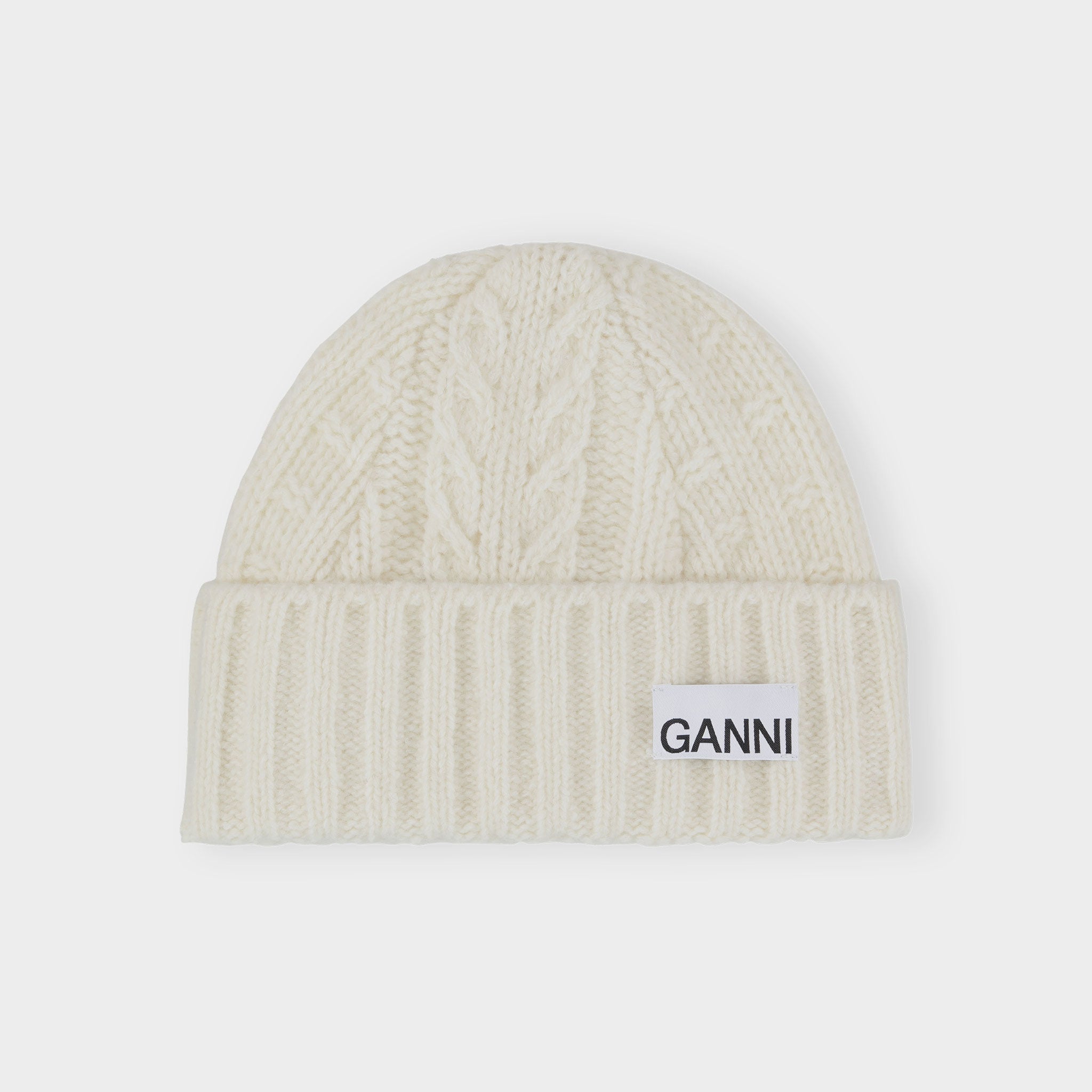 Flat photo of the classic white cable knit beanie from GANNI.