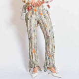 A model wears the pleated Dahlia trousers with light green, grey graphic floral print - front view.