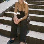 Model sitting on the steps wearing the Echo Jean - Black.