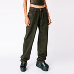 A model wears the baggy faded black Echo Jeans by Miaou, paired with the matching strappy Kiko corset, front view.