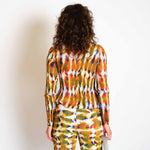 A model wears the orange and green graphic Eddie top - back view.