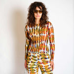 A model wears the orange and green graphic Eddie top - front view.