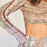 A model wears the cropped, long-sleeved, multicolored knit Eteri sweater with purple metallic dipped sleeves - detail view.