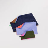 A set of 3 nylon travel pouches with different colored panels on each side of each bag, with the pouches laid flat.