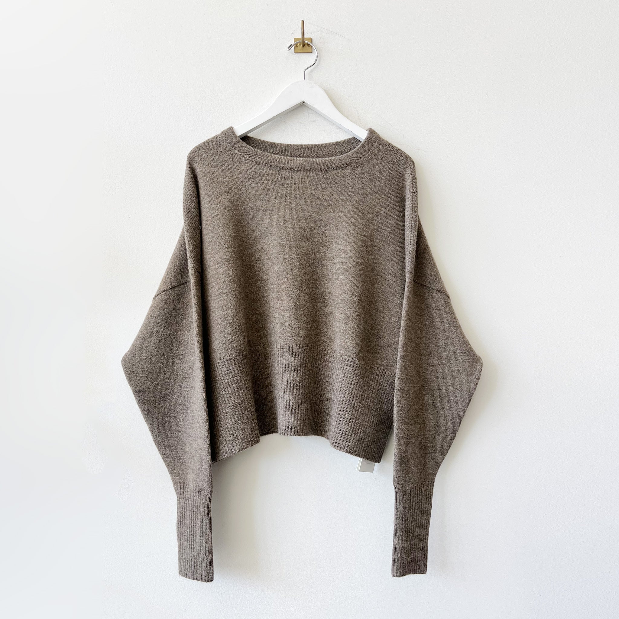 A boxy crewneck sweater with long loose sleeves and a cropped waist.